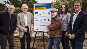 ITS team in front of sponsors sign